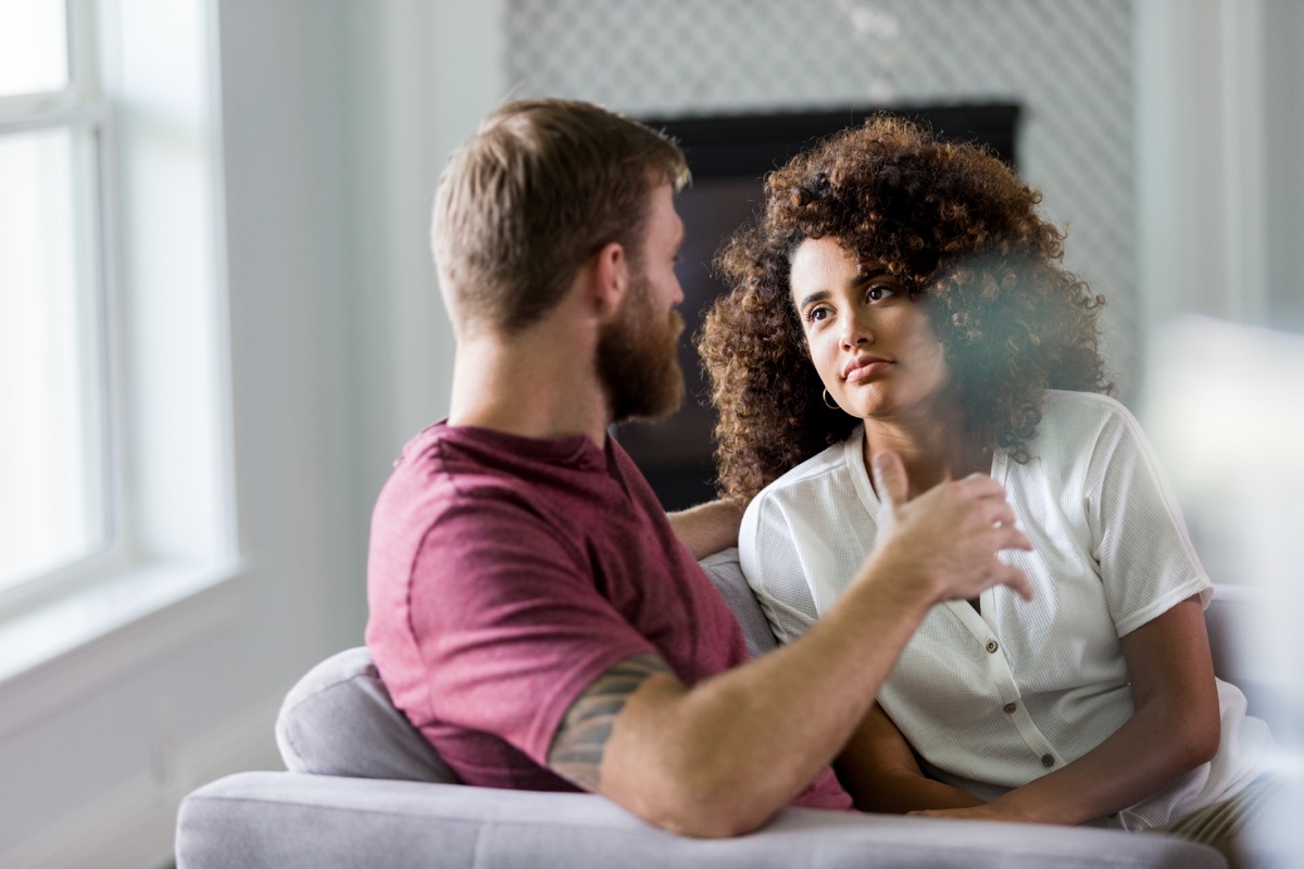 Die erwachsene Frau hört aufmerksam und ernsthaft ihrem nicht wiederzuerkennenden Ehemann zu, während er seine Gedanken über ihr neues Zuhause teilt.