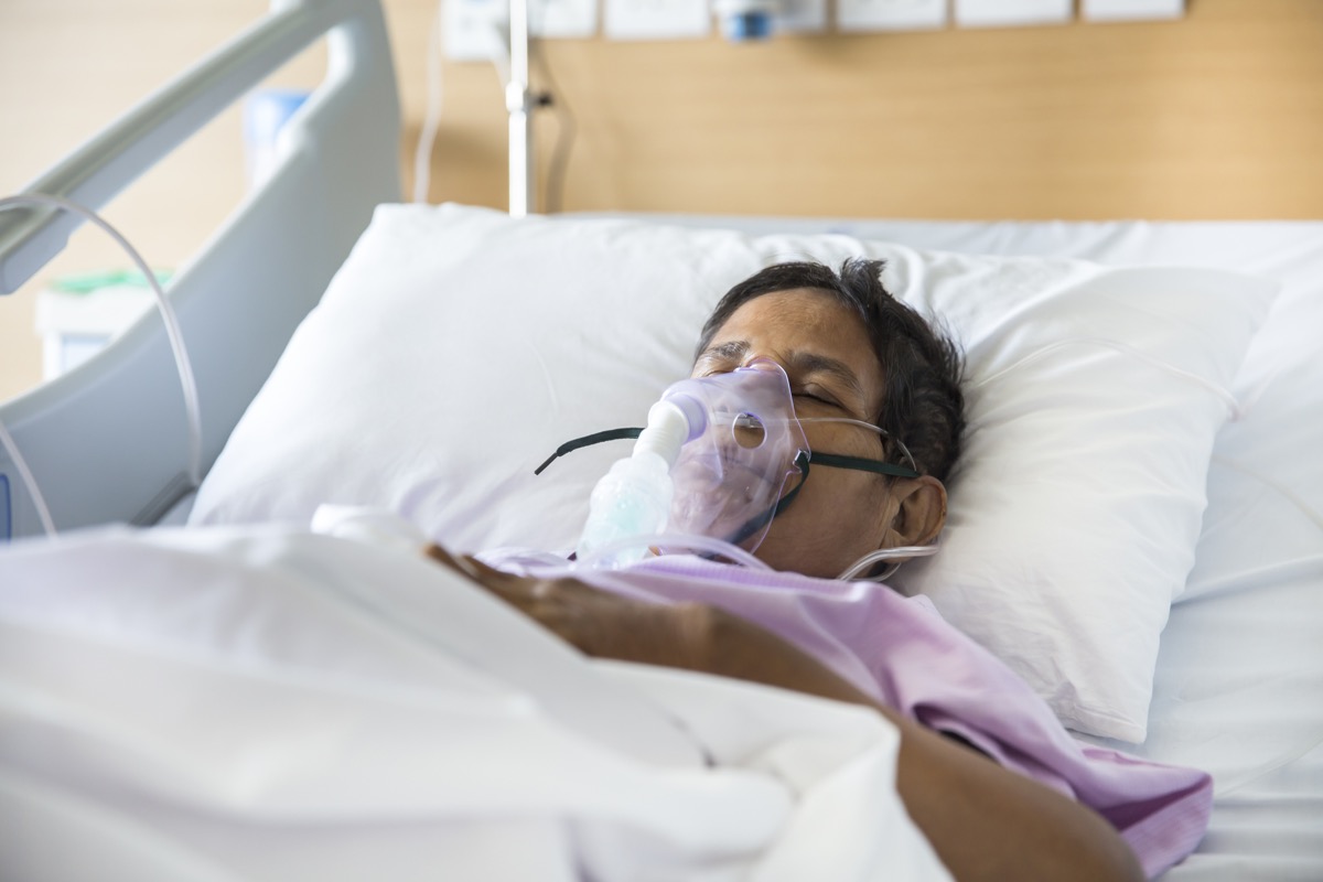woman in hospital bed with breathing mask on