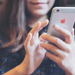 A closeup of a woman using an iPhone