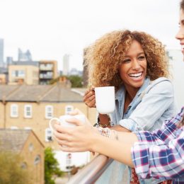 two women drinking coffee on rooftop