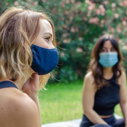 Two friends talking in the park with face masks