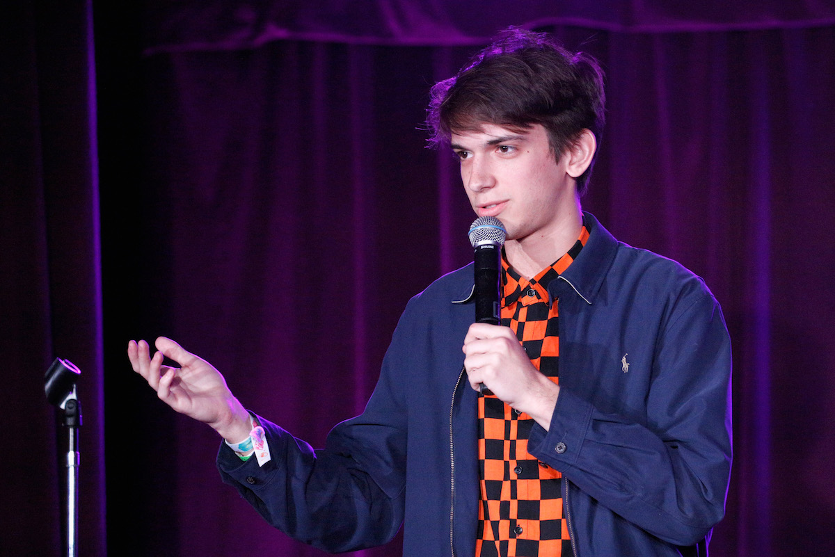 Andrew Dismukes performing standup comedy at Clusterfest in 2018