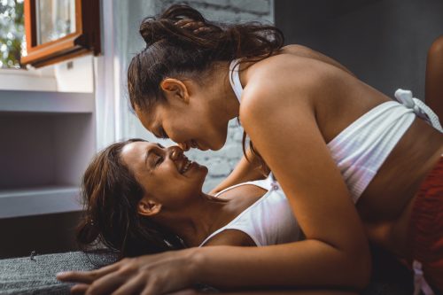 Female couple cuddling in bed