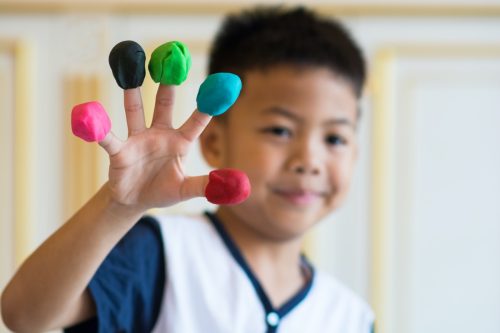 Little boy with Play-Doh on fingers