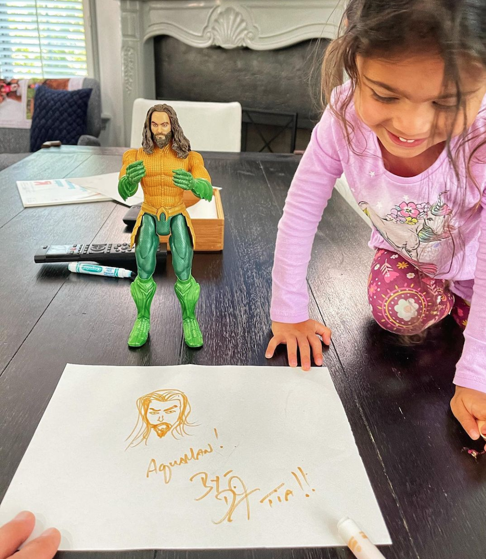 Tiana Johnson next to her dad's drawing of Aquaman