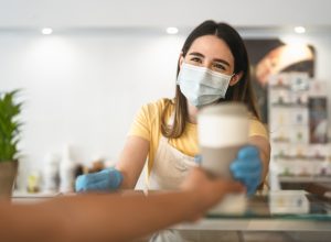 A barista handing a coffee to a customer