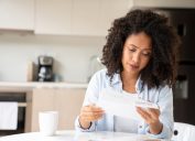 Woman looking concerned while reading her bills