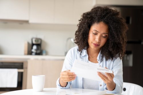 Woman looking concerned while reading her bills