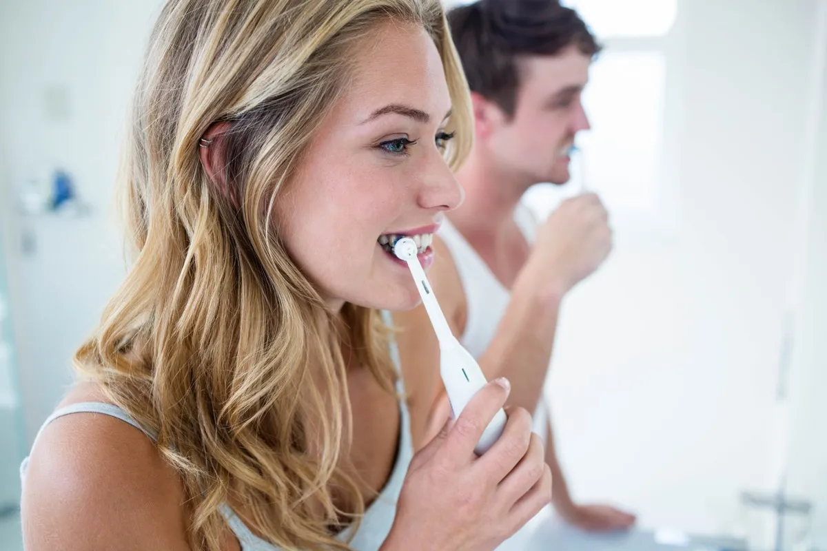 a couple brushes their teeth