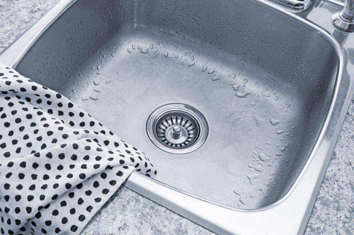 Clean metal sink and polka dot kitchen towel.