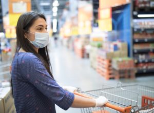Woman with face mask, shopping for groceries in a supermarket during COVID-19 pandemic