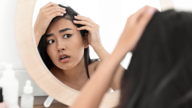 Woman checking hair in mirror