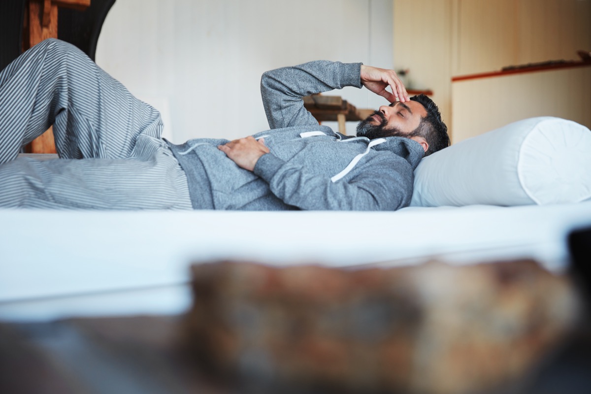 Shot of a mature man lying on his bed feeling exhausted