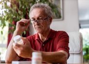 older man looking at supplements or medicine