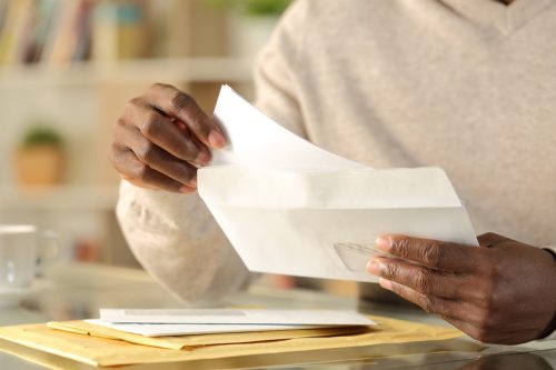 hands putting a letter inside an envelope
