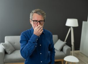 man smells something bad in his house