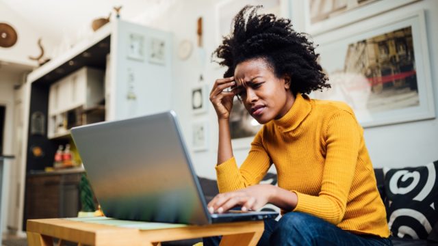 female freelancer working from home using her laptop and encountering some problems concerning her business