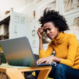 female freelancer working from home using her laptop and encountering some problems concerning her business