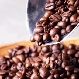 metal scoop pouring coffee beans