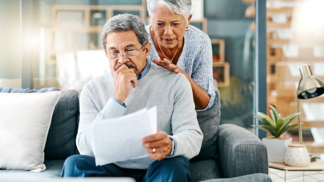 Shot of a mature couple looking worried while going through paperwork together at home