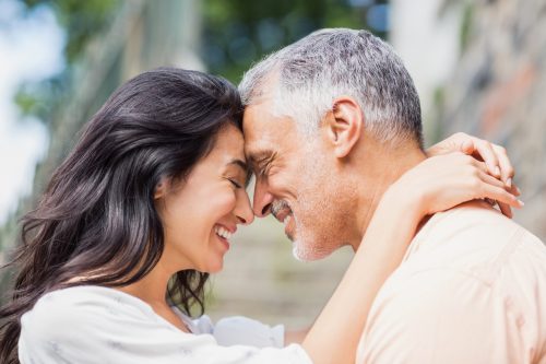 Tânără își îmbrățișează partenerul mai în vârstă
