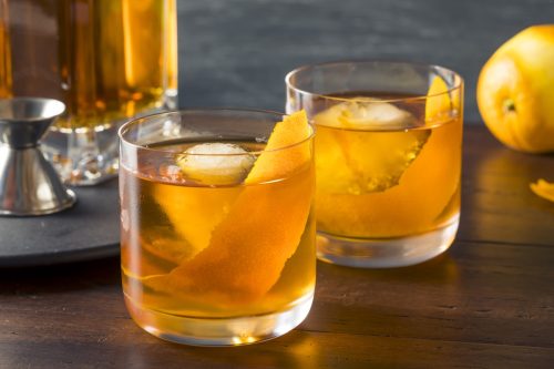 old fashioned cocktail with fruit peel and large ice cubes