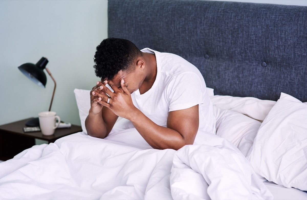 young man in bed with severe headache