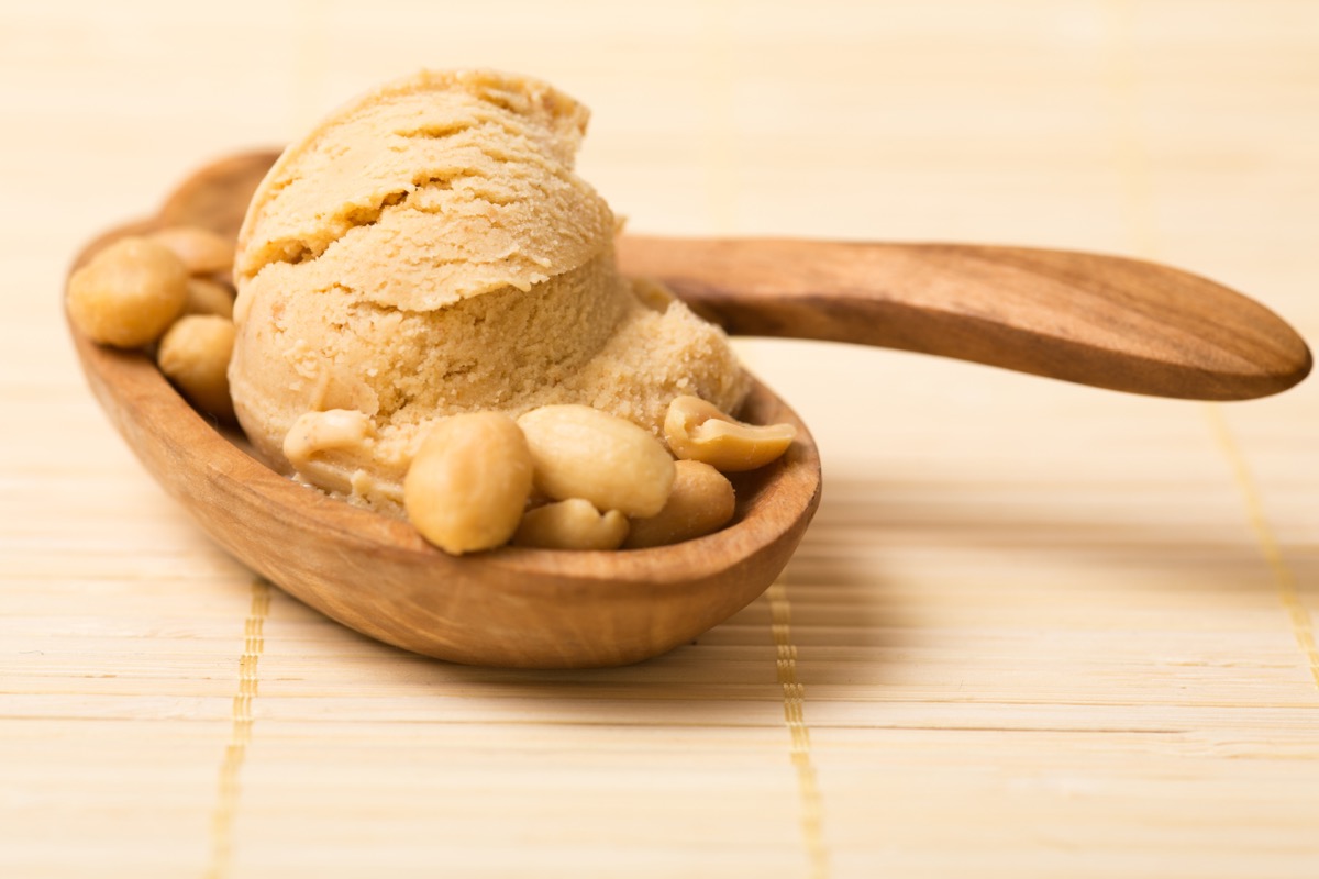 peanut butter ice cream in bowl with whole peanuts