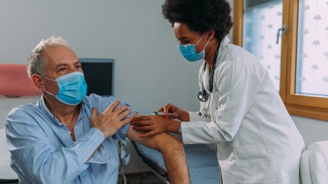 doctor injecting a vaccine into the patient's arm.