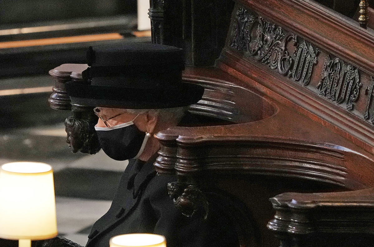 Britain's Queen Elizabeth II sits alone in the quire of St George's Chapel during the funeral service of her husband Britain's Prince Philip, Duke of Edinburgh in Windsor Castle in Windsor, west of London, on April 17, 2021.