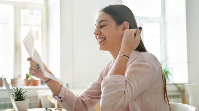 Happy female employee excited reading promotion letter