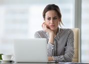 woman looking at laptop, worried look on face