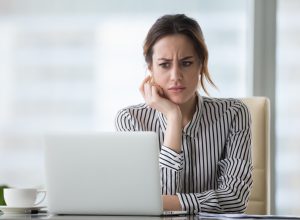 woman looking at laptop, worried look on face