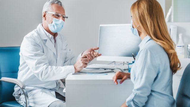 Male doctor speaks to woman patient