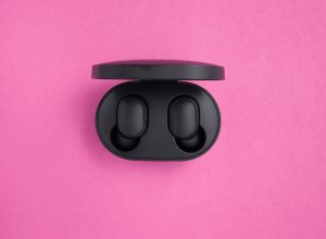 Wireless headphones in a mockup case on a bright pink background