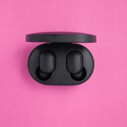 Wireless headphones in a mockup case on a bright pink background