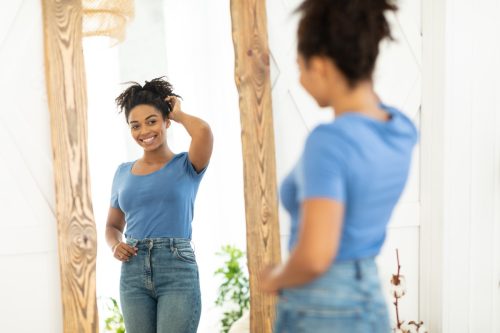 confident woman looking in mirror