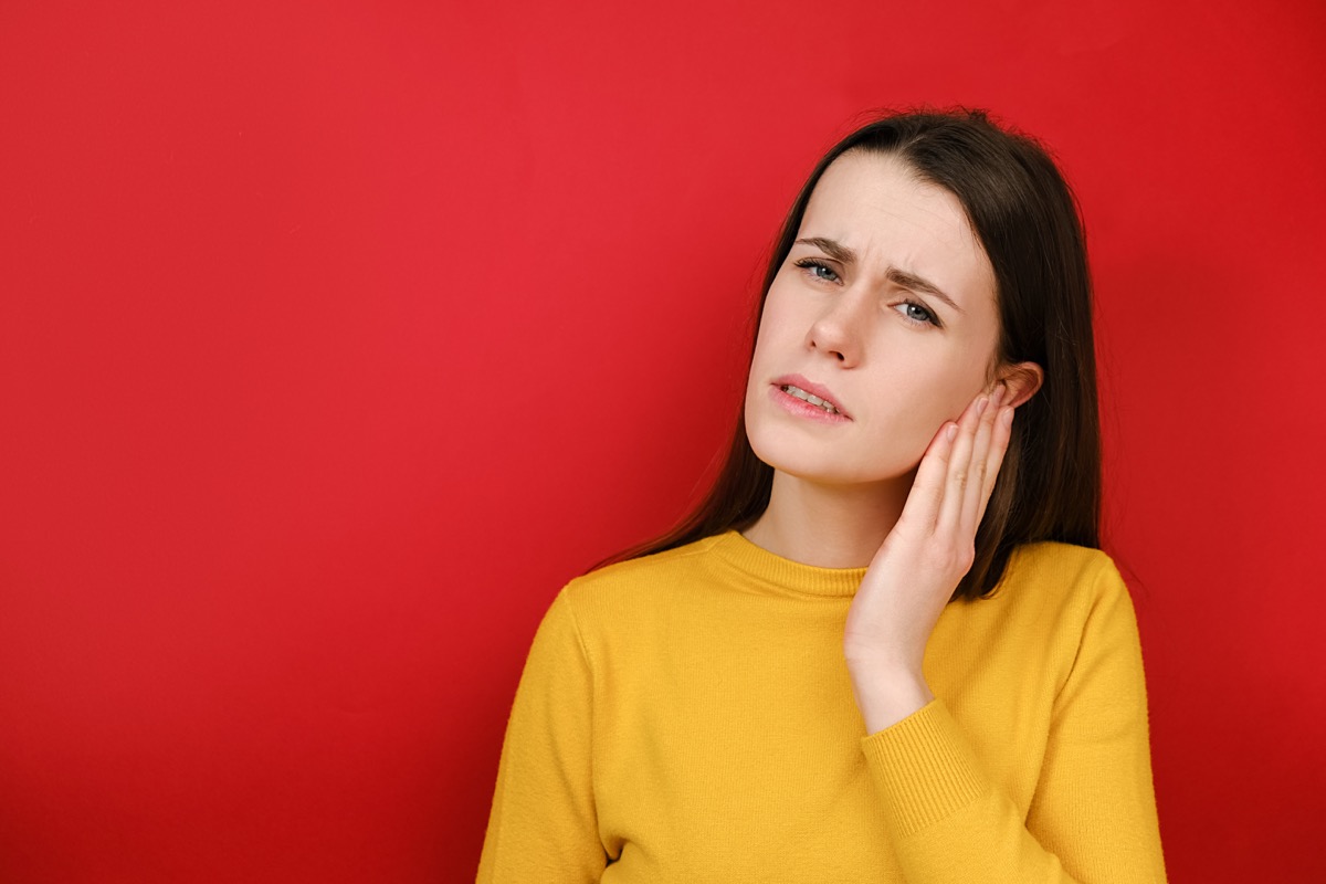 woman with ear pain, hand over ear