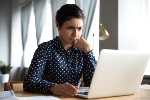 Професионална употреба ученика, поглед на лаптоп у кућној канцеларији, осећај фрустрације због проблема са компјутерским софтвером, забринутост због перцепције негативних вести на интернету