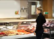 A woman shopping in the seafood section of the grocery store