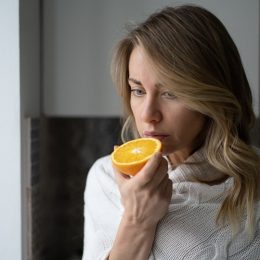 woman trying to smell half an orange