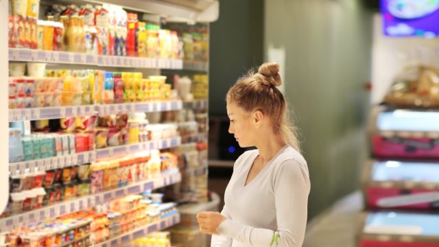 young woman shopping for groceries in dairy case