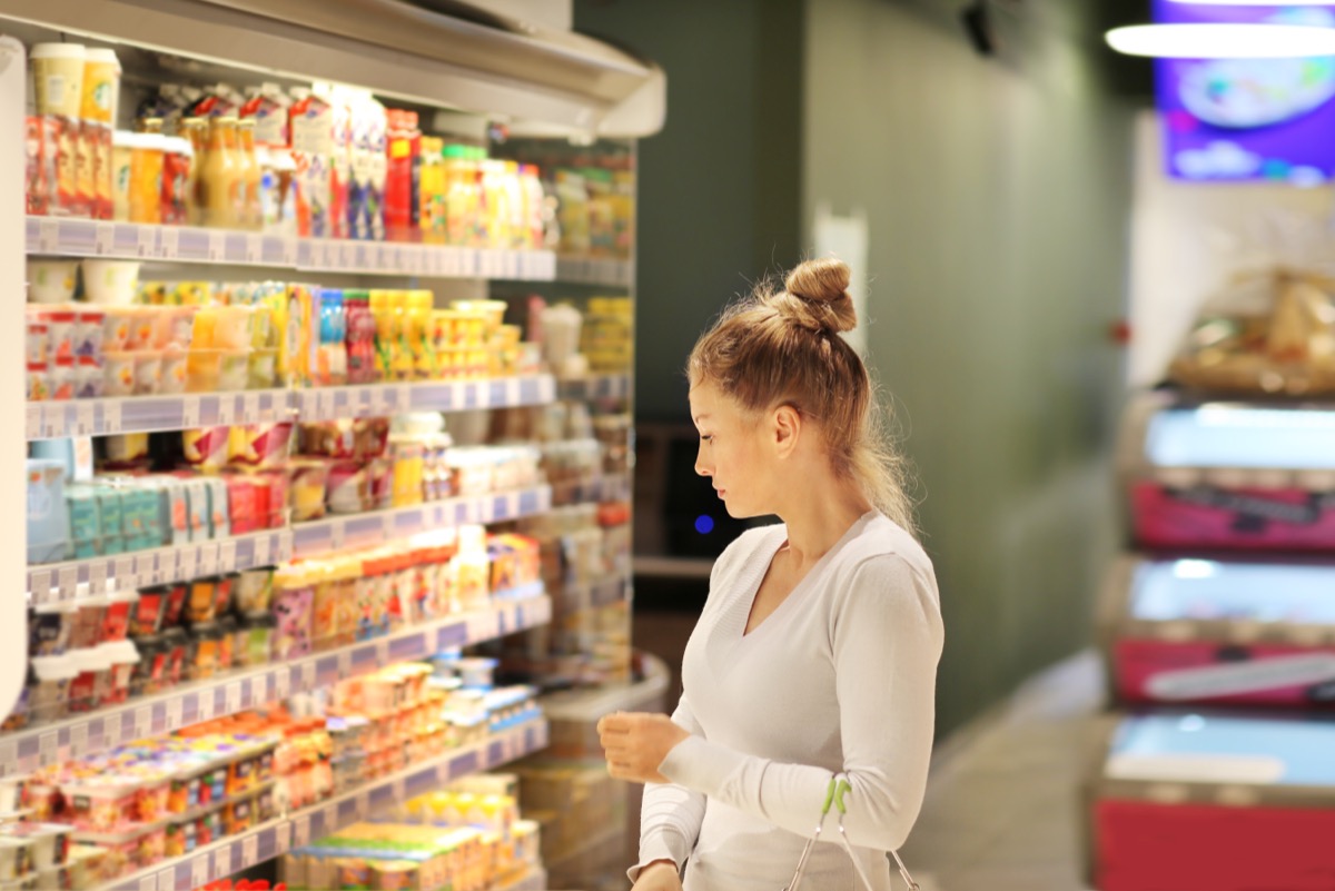 young woman shopping for groceries in dairy case