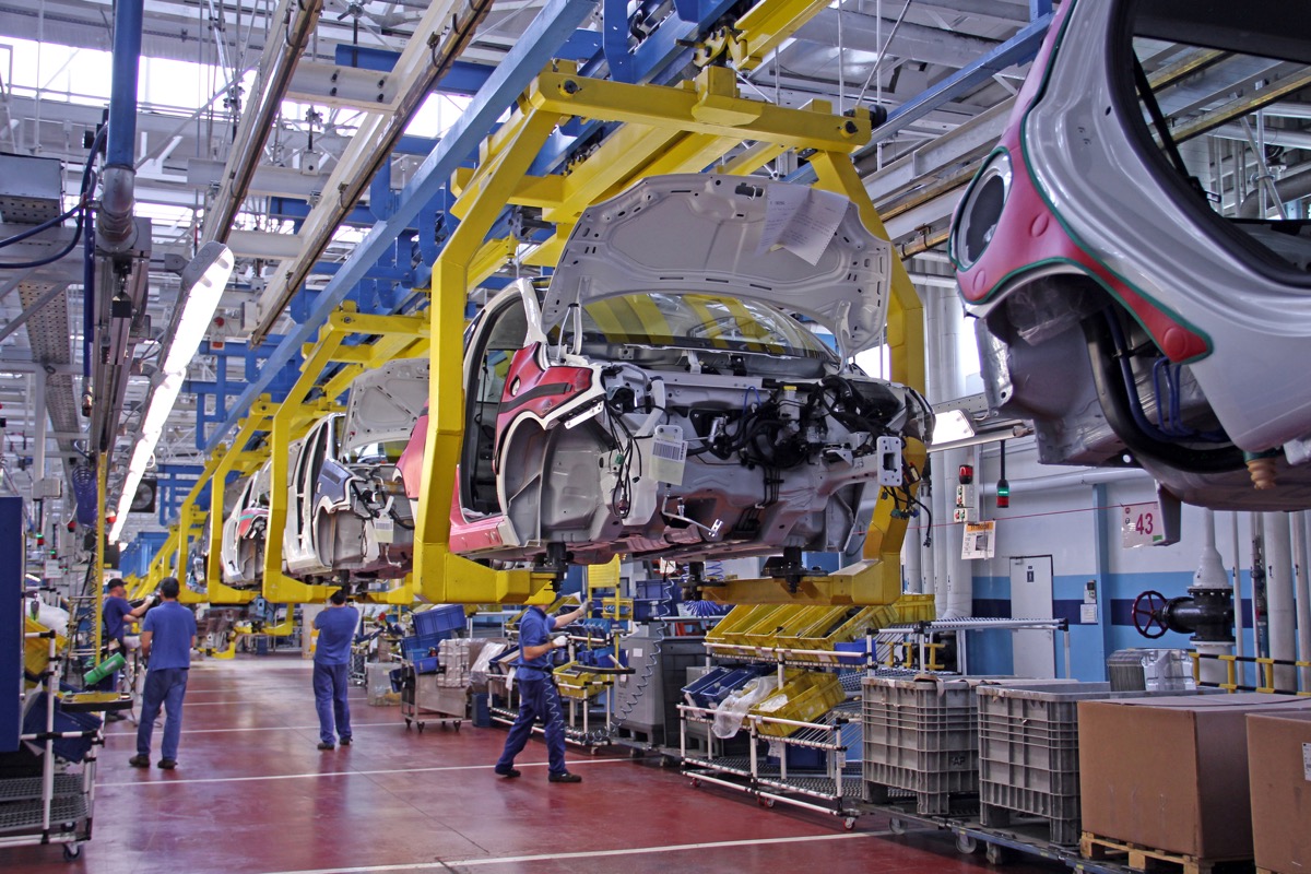 factory workers, cars being built in a factory