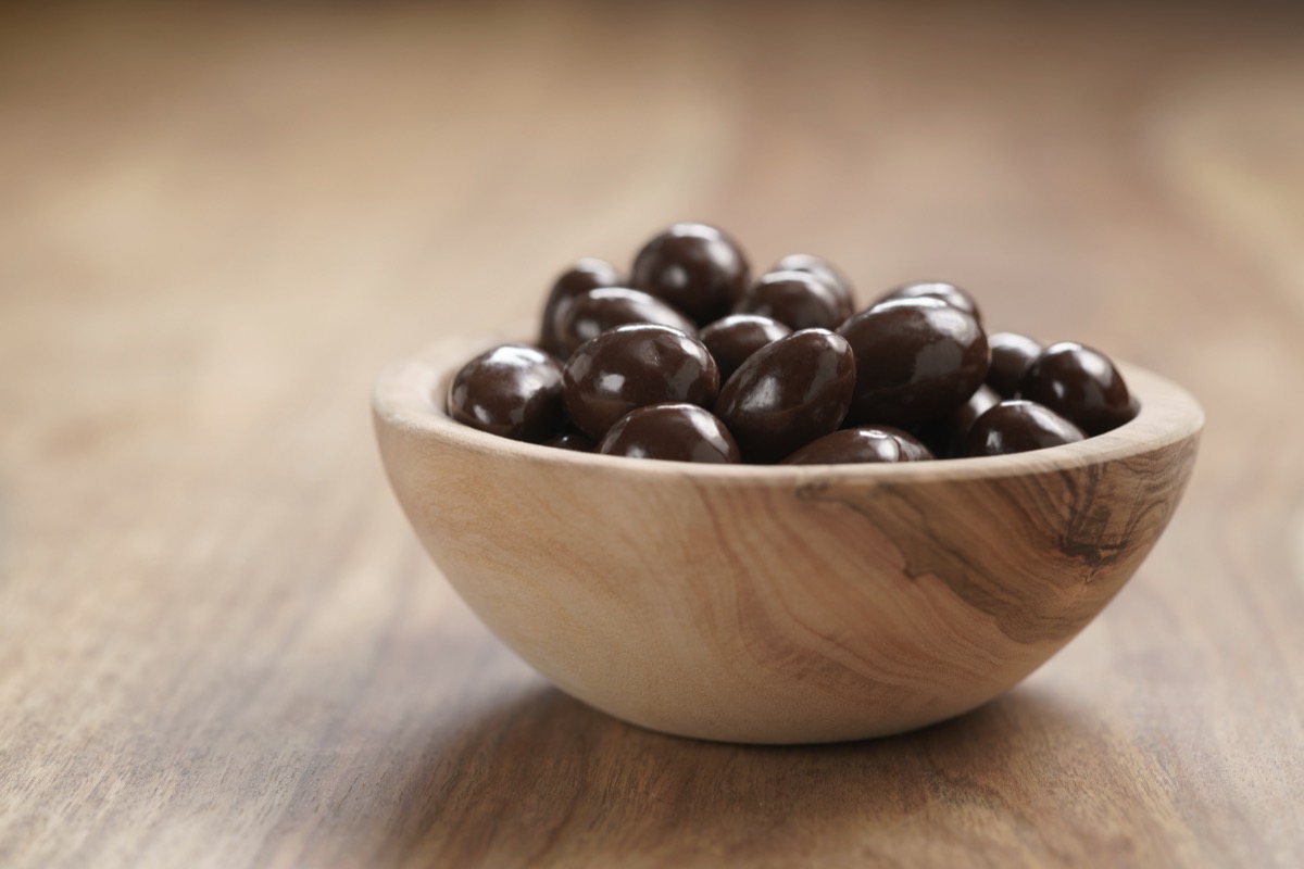 chocolate covered fruit or nut in wooden bowl