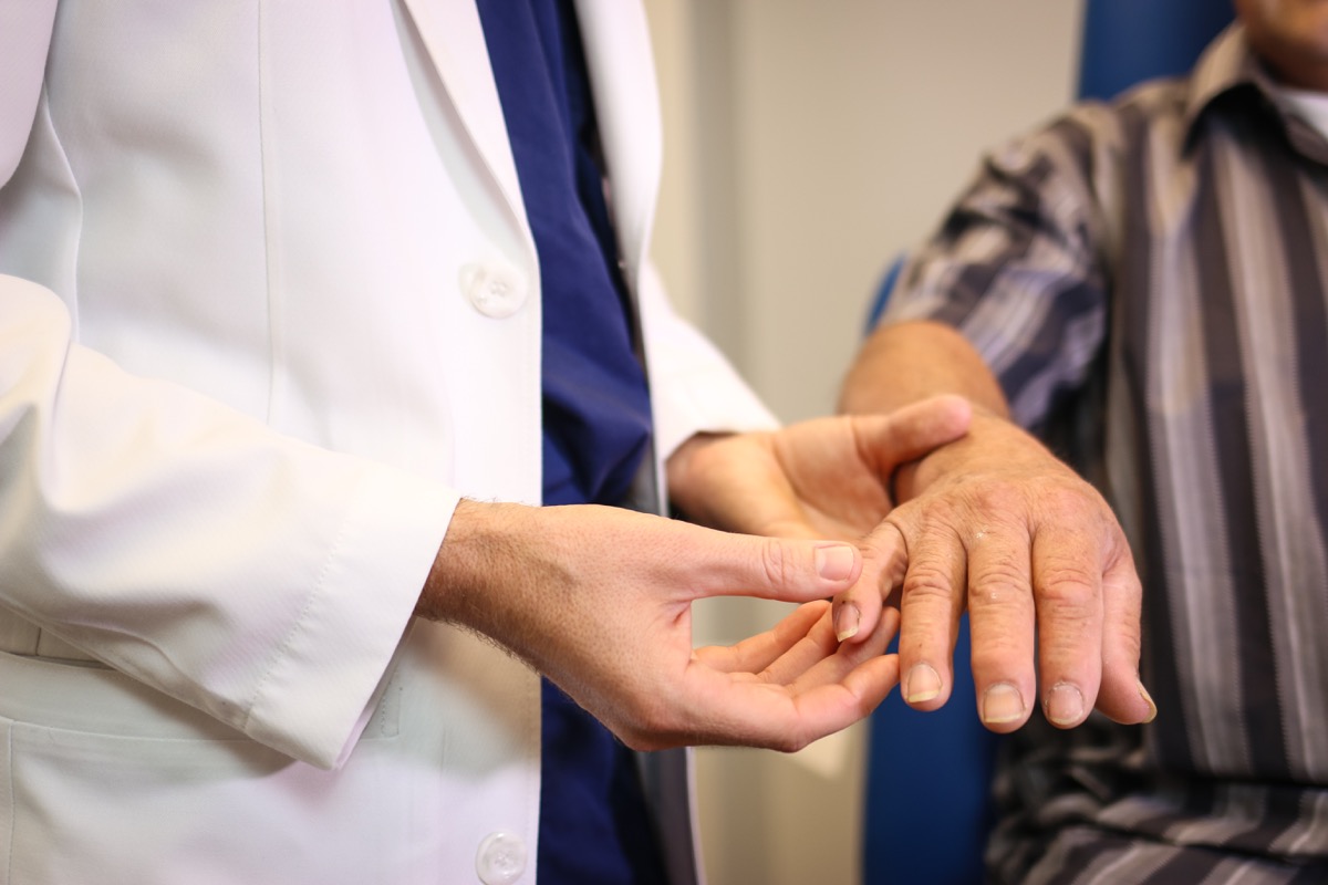 doctor looks at a patient's nails