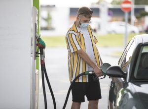 Young Adult Man With Protective Face Mask Refueling Car.