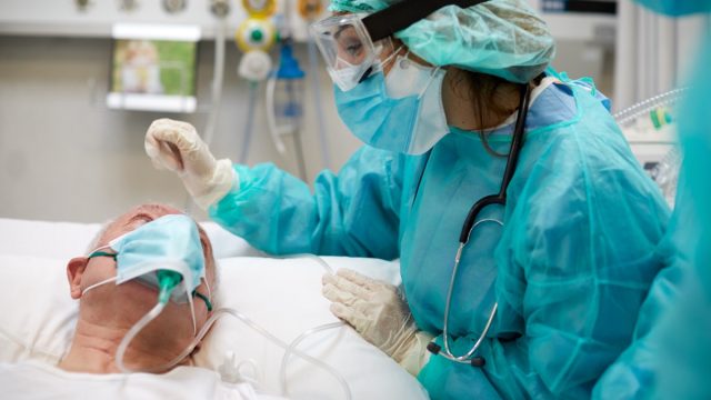 Nurse is comforting a covid patient at the ICU