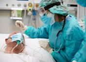 Nurse is comforting a covid patient at the ICU