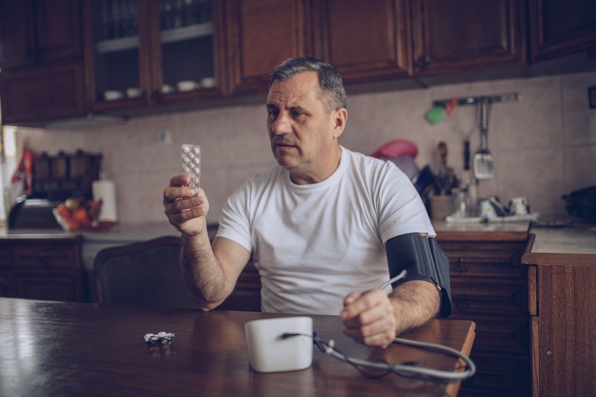 man checking blood pressure with blood pressure medication